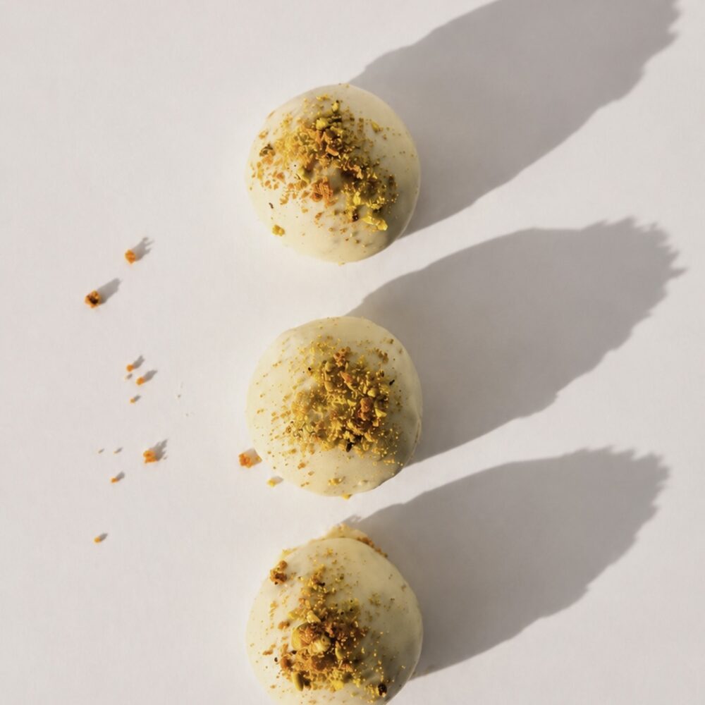 A BITEY protein chocolate in white chocolate finished with pistachio and Biscoff crumb